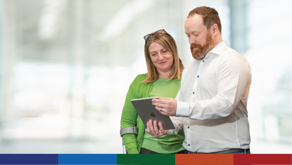 An image of two staff members looking at a tablet computer together.